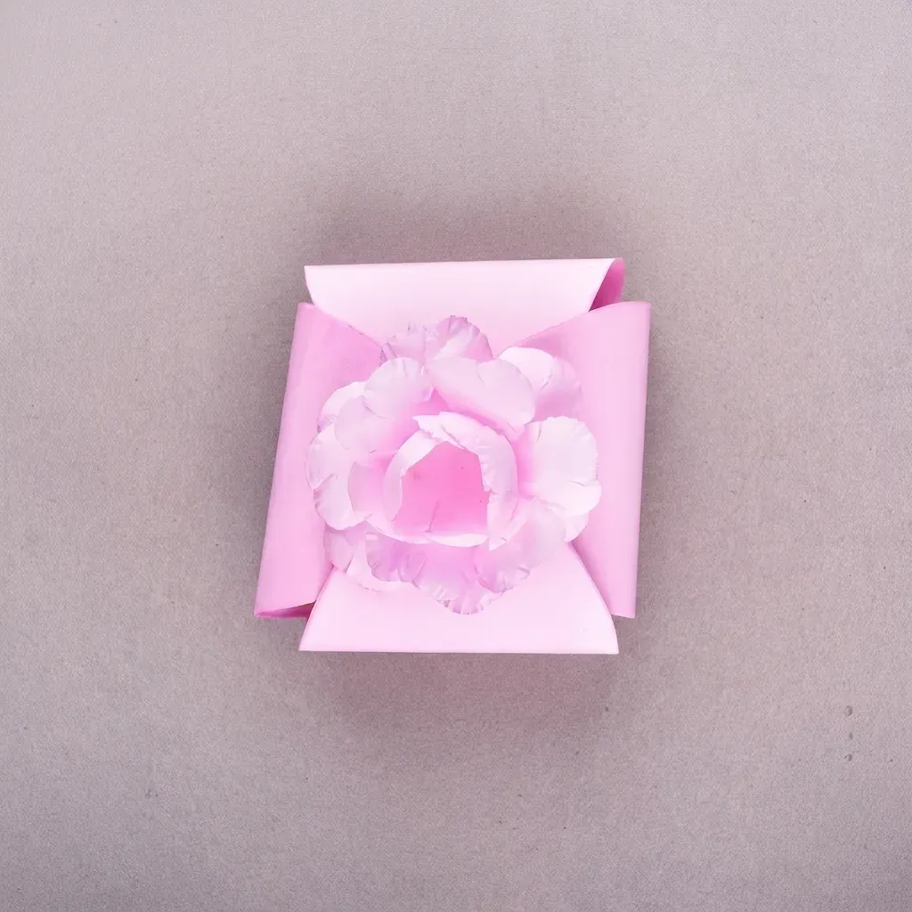 Caixinha cartonada rosa da Embalarte com flor de papel camélia no topo