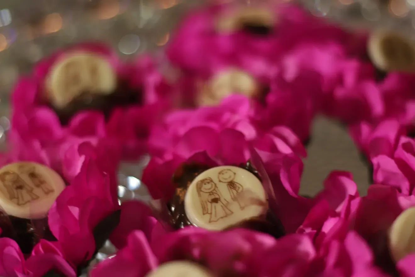 Bem casados da Embalarte em forminhas pink, com bombons estampados de noivinhos, numa bandeja de cristal na mesa de casamento
