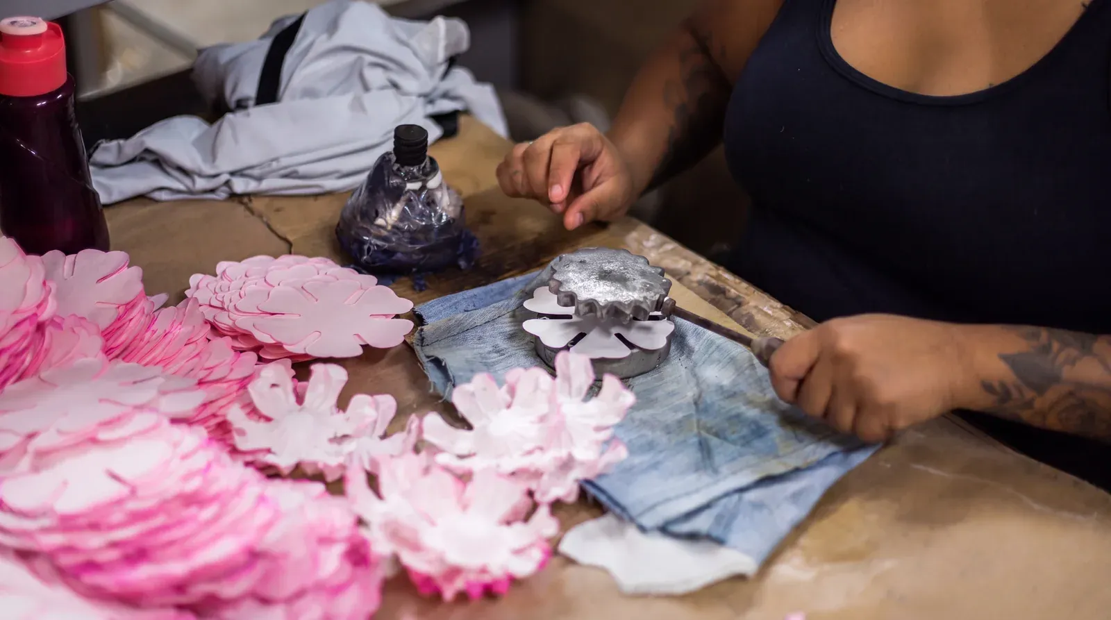 Mãos da artesã da Embalarte montando uma forminha em formato de rosa